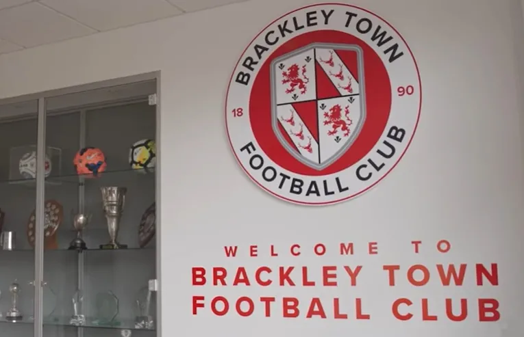 Biểu tượng (crest) của câu lạc bộ Brackley Town FC, phản ánh lịch sử và biệt danh &quot;The Saints&quot;.