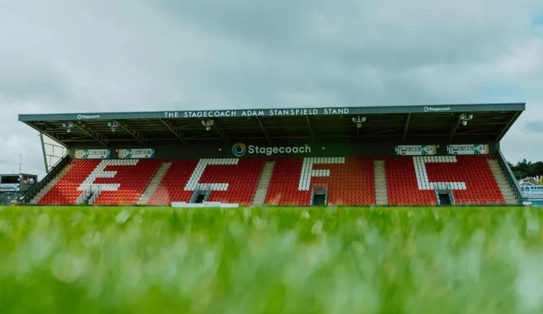 Hình ảnh khán đài Stagecoach Stand tại sân St. James Park, Exeter, với hàng ghế đỏ nổi bật