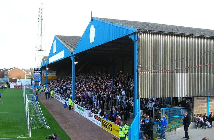 Khán đài Warwick Road End, trái tim sôi động của sân Brunton Park Carlisle United.