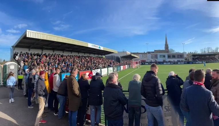Khung cảnh Meadowbank Stadium vào ngày có trận đấu của Dorking Wanderers, thể hiện không khí sôi động và đông đúc của các trận bóng đá địa phương