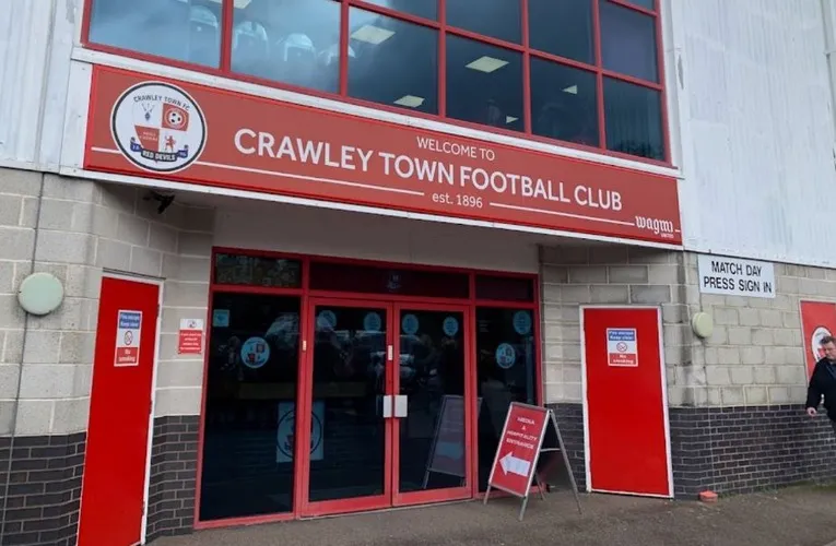 Lối vào chính Broadfield Stadium ở Crawley, giản dị mà thân thuộc, chào đón người hâm mộ qua bao thế hệ.